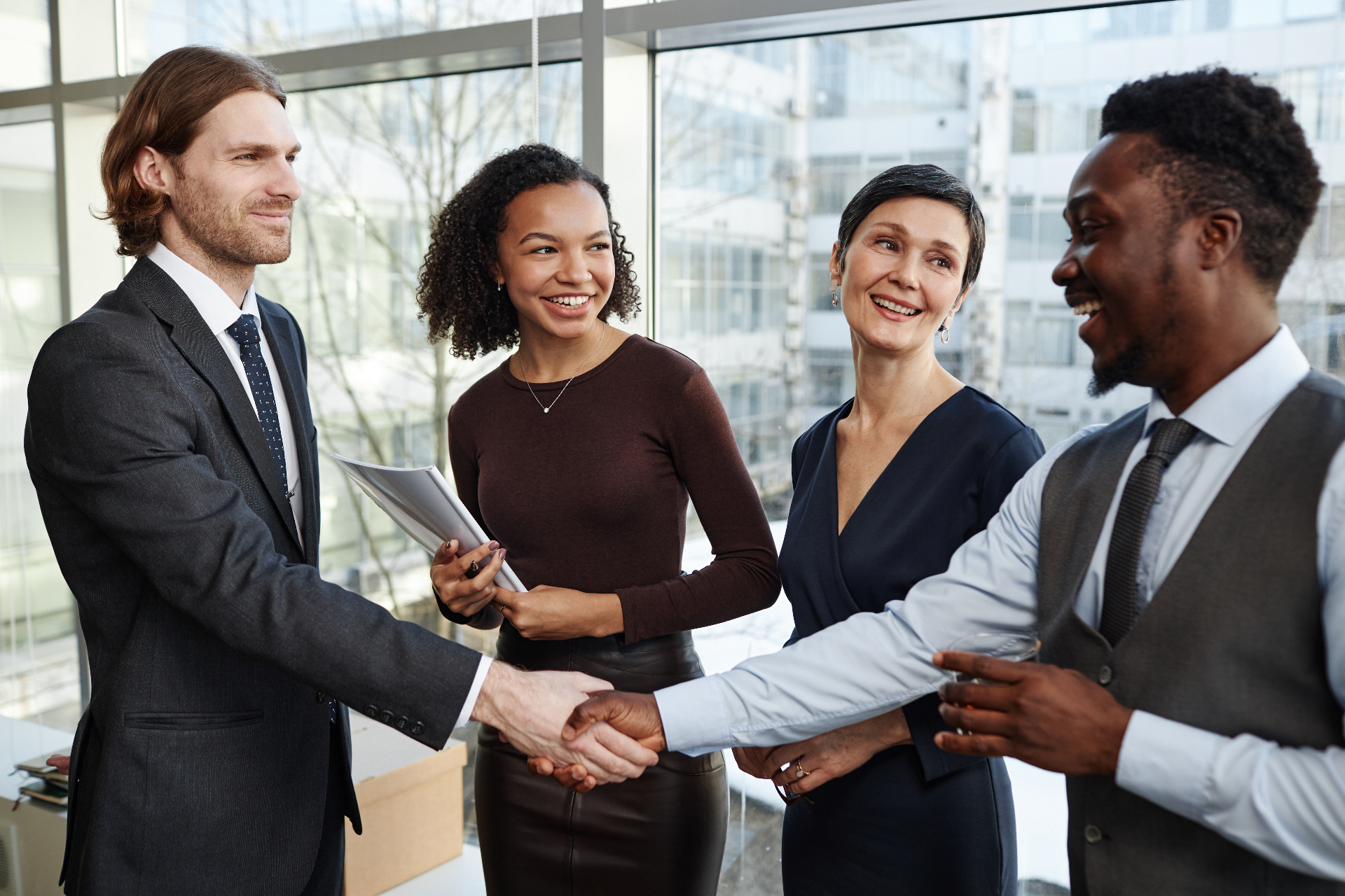 Diverse business professionals shaking hands after a successful partnership meeting